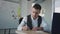 Young man marketer writing notes and hanging sticker on whiteboard in office.