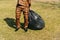 A young man in a mask is engaged in cleaning garbage in a park. pandemic environment concept