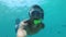 Young Man in a Mask with a Snorkel Dives Under the Water and Films Himself