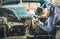 Young man mechanical worker repairing old vintage car body with