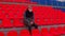 Young man in medical mask sitting on stadium bleachers alone. Sad adult male protecting yourself from diseases at sports