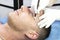 Young man microblading procedure to improve the condition of a mans eyebrows