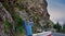 Young man in the middle of highway and looking away, enjoying fresh air near beautifull mountain. Portrait of traveler