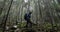 A young man in a mountain hiking with a backpack among the trees