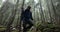 A young man in a mountain hiking with a backpack among the trees