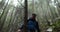 A young man in a mountain hiking with a backpack among the trees