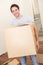 Young man on moving day carrying cardboard box
