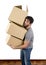 Young man moving in a new house carrying pile of cardboard boxes