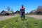 A young man with a mower in his hands mows green grass-the concept of spring seasonal work in the garden