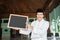 Young man muslim holding and pointing black blank board