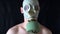 Young man with naked torso in the mask straightens his tie