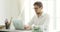 Young man office worker working typing on laptop at table in modern office.