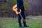 Young man with an orange guitar outdoors