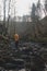 Young man in an orange jacket relaxes in the flow of a river in the Wallonia region of Belgium. Reflection of a man in the river