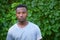 Young man outside portrait green leafs vine vegetation background