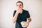 Young man  over white background. Guy eating popcorn from bowl. Tasty delisious snack. Glutton man divour meal.