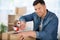 Young man packing things and taping boxes