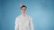 Young man with party hat is surprised flying bubbles on a blue background.