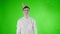 Young man with party hat is surprised flying bubbles on a green screen .