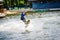 A young man performs an acrobatic jump on a surfboard on Lake Tr