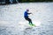 A young man performs an acrobatic jump on a surfboard on Lake Tr