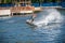 A young man performs an acrobatic jump on a surfboard on Lake Tr