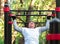The young man performs a sports exercise pull-up on the bar. Training on the street to develop the strength of the back muscles,
