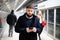 Young man with phone on subway platform