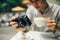 Young man photographer taking picture sitting at table in coffee