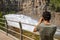 Young man photographing the water outlet of a dam