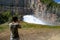 Young man photographing the water outlet of a dam