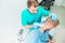 Young man at the physiotherapy receiving laser therapy massage. A chiropractor treats patient`s cervical spine in medical office.