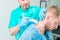 Young man at the physiotherapy receiving laser therapy massage. A chiropractor treats patient`s cervical spine in medical office.