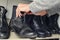 Young man picking a pair of boots from the closet