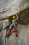 Young man place a belay device into a crack.