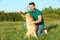 Young man playing with adorable Akita Inu dog