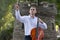 Young man playing cello outside. Cellist playing classical music on cello