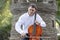 Young man playing cello outside. Cellist playing classical music on cello