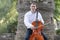 Young man playing cello outside. Cellist playing classical music on cello