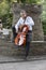 Young man playing cello outside. Cellist playing classical music on cello