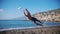 A young man playing frisbee on the beach. Jump and catching the disc