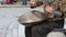 Young man is playing on the musical instrument Handpan in the city. Practice meditation.