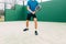 Young man playing paddle tennis on a green court