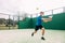 Young man playing paddle tennis on a green court