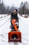 Young man playing with a snowplough in the winter