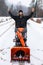 Young man playing with a snowplough in the winter