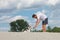 Young man is playing stick pull game with his fow terrier dog at the beach