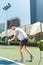 Young man playing tennis outdoors in a modern district of the city