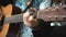 The young man plays hands and on a classic acoustic wooden guitar on the street