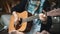 The young man plays hands and on a classic acoustic wooden guitar on the street